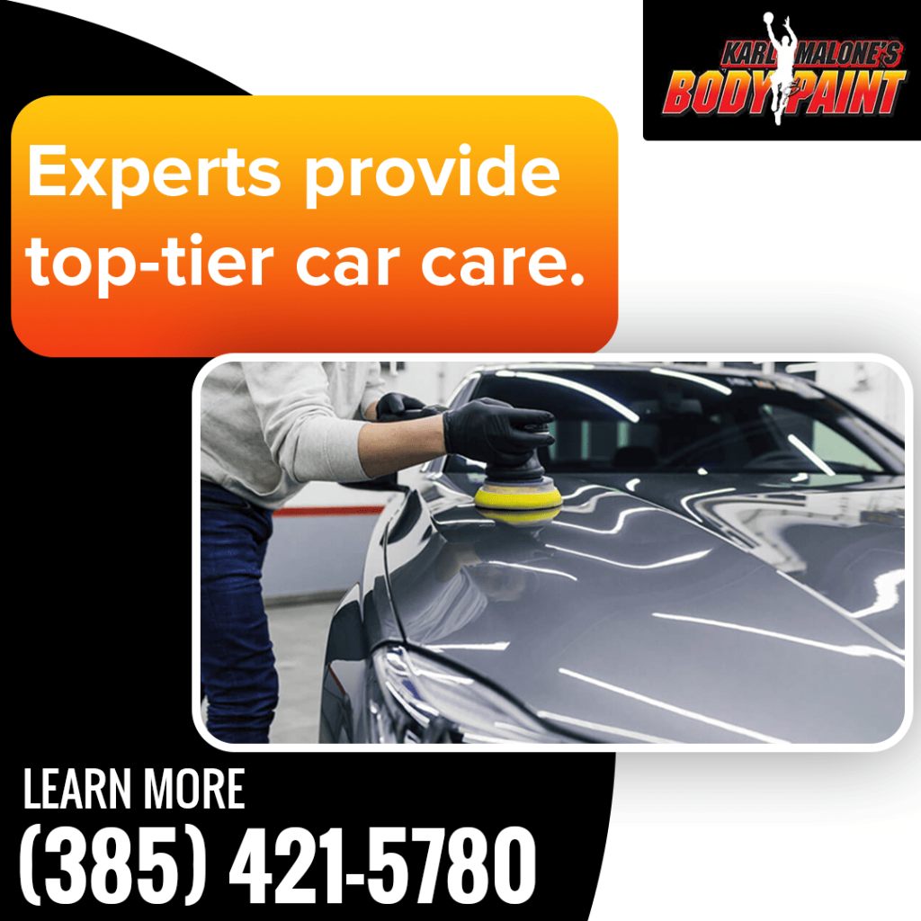 An expert technician at Karl Malone's Body & Paint polishes the hood of a gray car to a high shine.